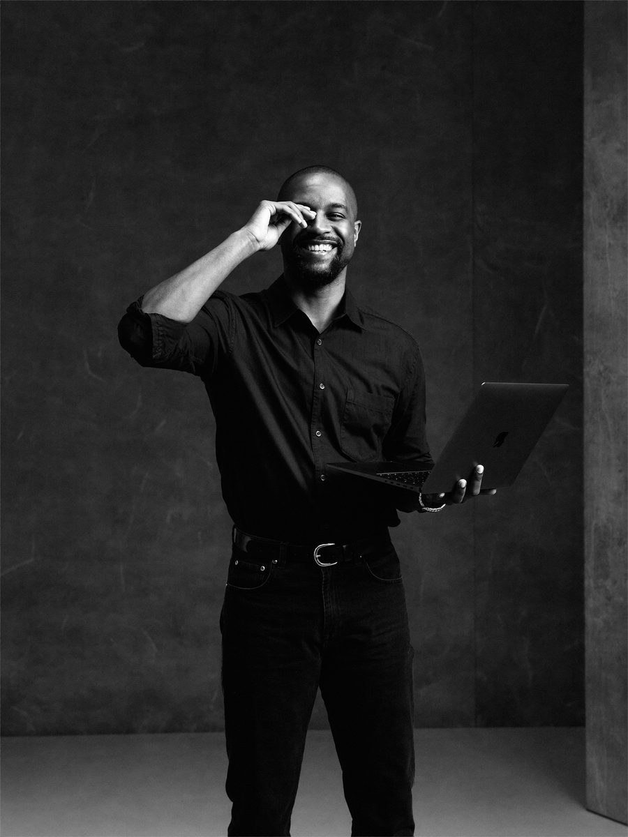 Portrait of a smiling man holding a laptop